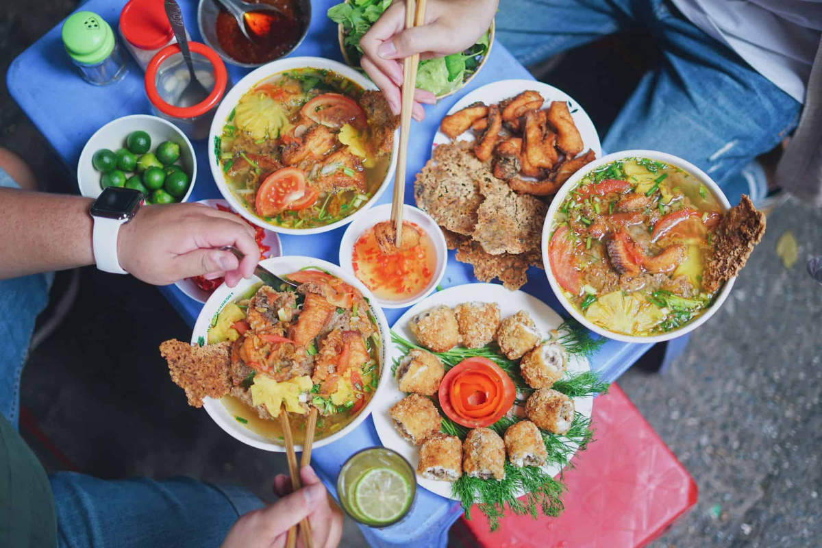 Bowls of Pho, Bun Cha, and Banh Cuon served along Hanoi Train Street